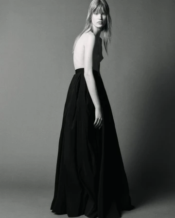 Model in a long black skirt standing against a neutral studio background for The Travel Almanac project.