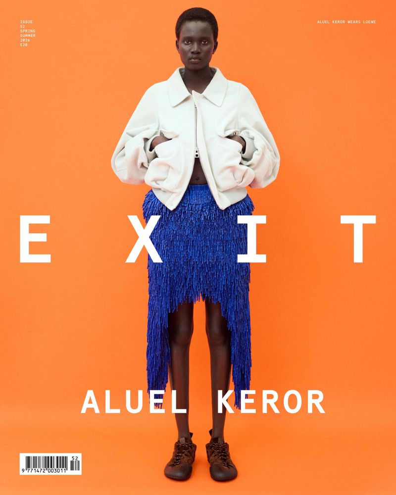 Fashion magazine cover featuring a full-length shot of a woman in a light jacket and blue fringe skirt against an orange background.