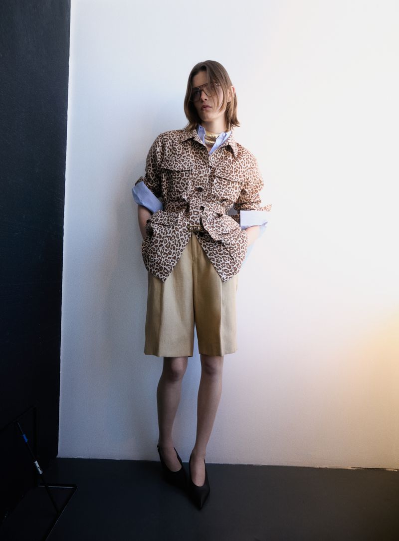 Model in leopard print jacket and beige shorts standing against a studio background for D Repubblica