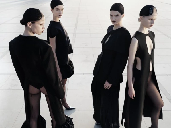 Four female models in black outfits and caps posing outdoors on a tiled plaza for Vogue Adria editorial Made in Adria.