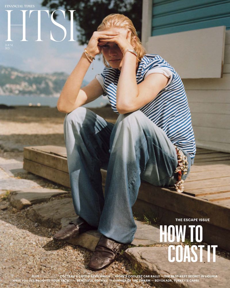 Magazine cover featuring a blonde woman in a striped shirt and jeans, sitting on steps by the sea, with an expression of thoughtful repose.