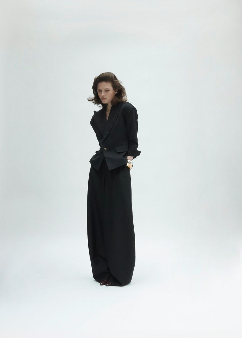Model Lonneke Te Kloese wearing a black blazer and wide trousers against a white seamless background for Puss Puss Magazine.