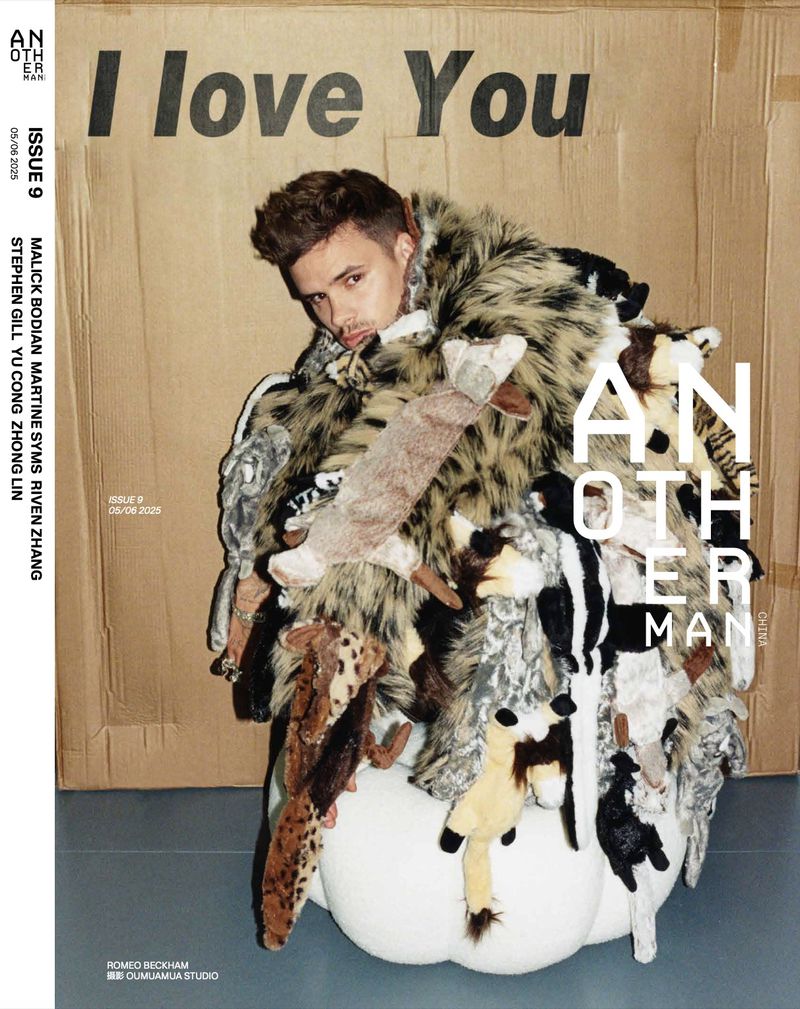 Magazine cover featuring a male model wearing a unique fur-like coat made of stuffed animals, posing in front of a cardboard background.