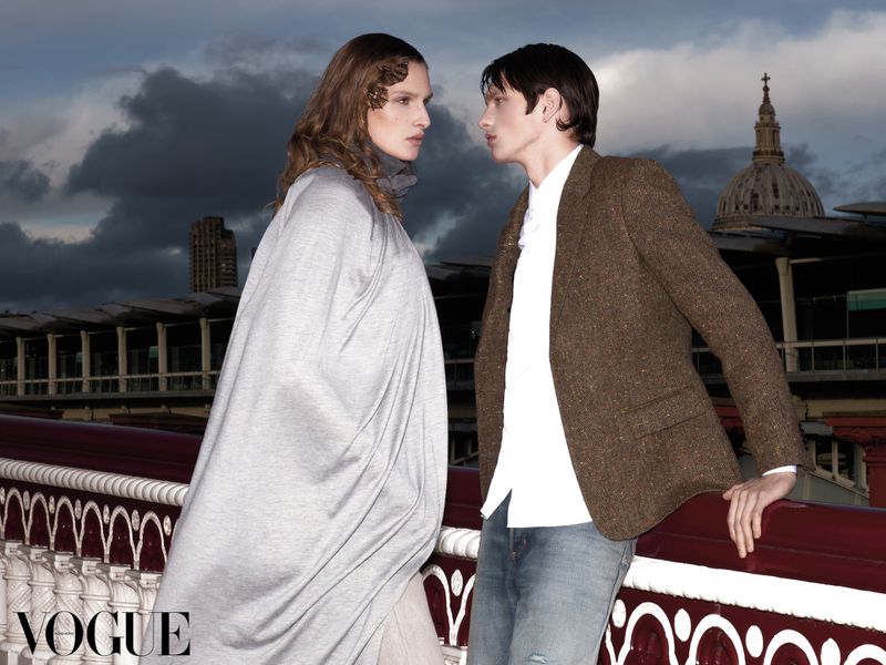 Two models posing on a bridge against a cloudy sky for Vogue Hong Kong, photographed by Carlos Duro.