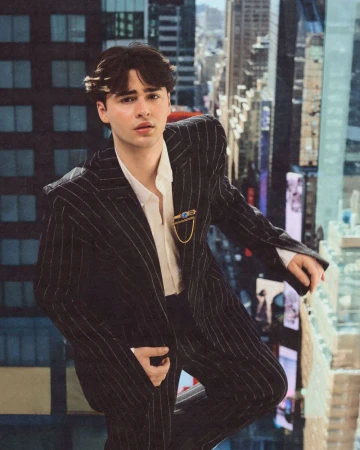 Portrait of Joshua Colley wearing a pinstripe suit against an elevated city backdrop for 1883 Magazine.