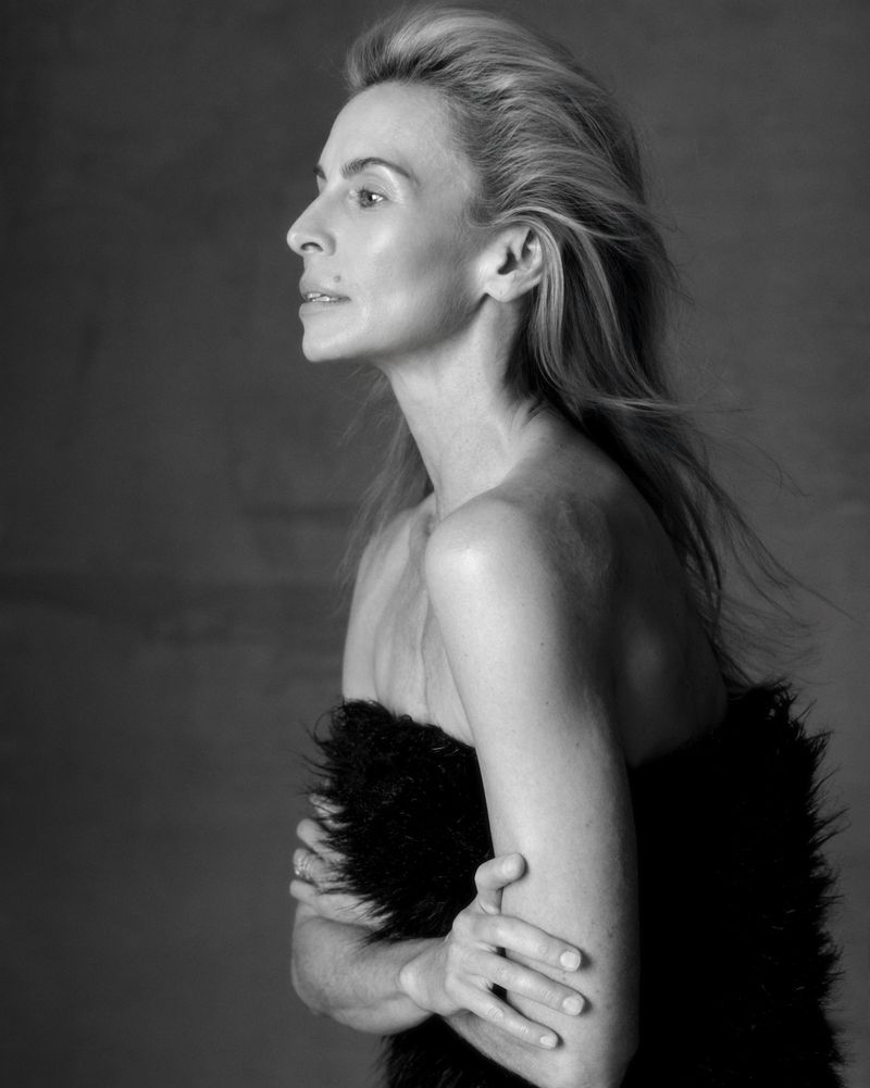 Black and white portrait of model Niki Taylor in profile wearing a textured black top against a dark background