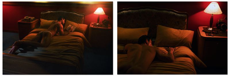 Man lying prone on a bed reading a book in a dimly lit bedroom with warm lamplight for Vogue China Men