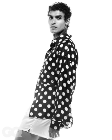 Monochrome portrait of a male model wearing a polka dot shirt against a bright white background for GQ Turkey.