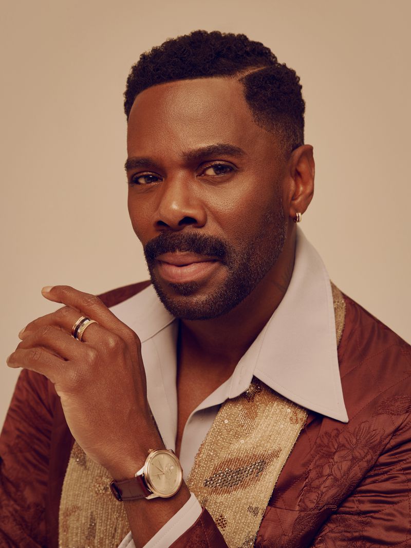 Portrait of actor Colman Domingo wearing a brown patterned jacket and white shirt against a neutral background.