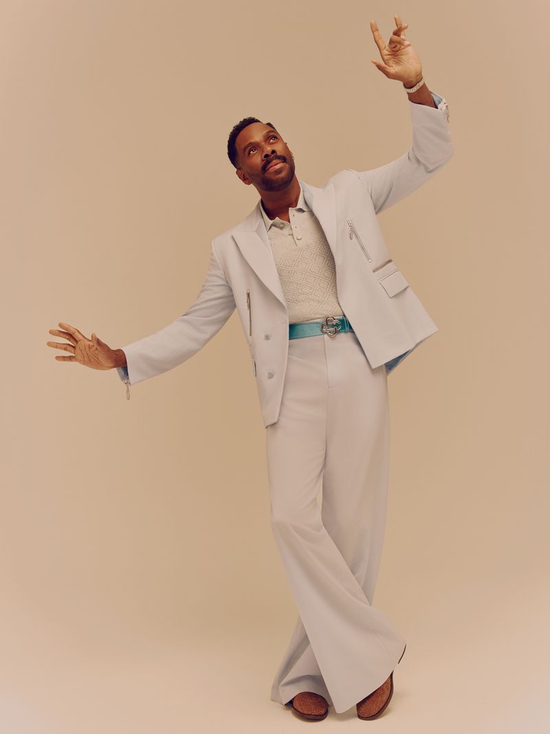 Colman Domingo wearing a pale blue suit with wide-leg trousers and a textured polo shirt against a neutral backdrop