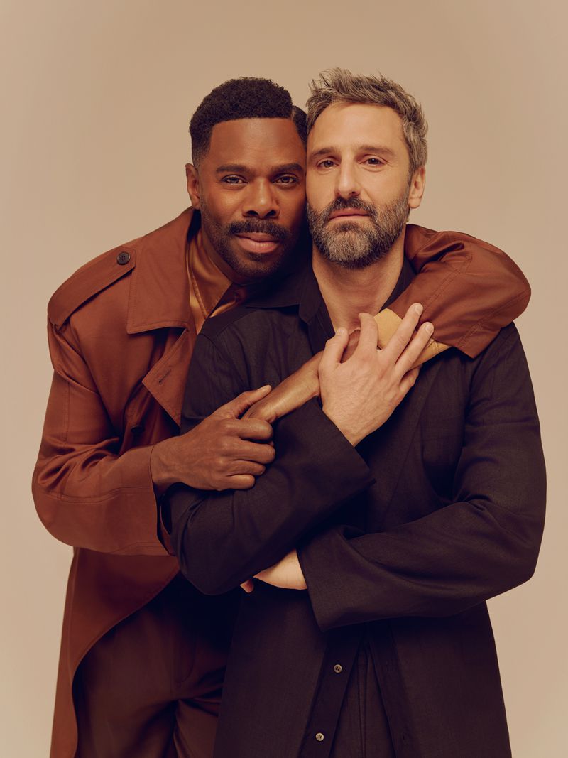 Portrait of Colman Domingo and Marco Calvani embracing against a neutral warm background for Out Magazine.