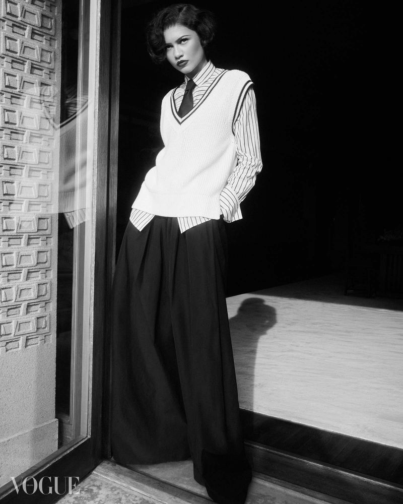 Zendaya wearing a white sweater vest and striped shirt in a monochrome editorial portrait for Vogue Brasil