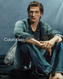 Male model Edoardo Sebastianelli seated in denim jacket and jeans for Calvin Klein Cone Denim project