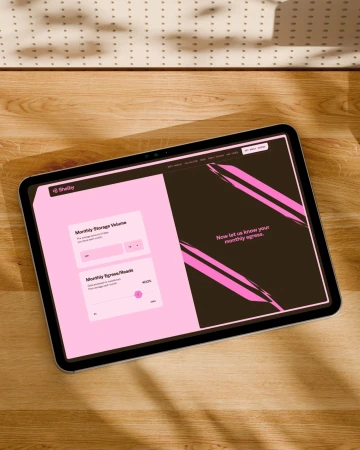 Tablet displaying a website UI mockup resting on a wooden desk with soft natural shadows