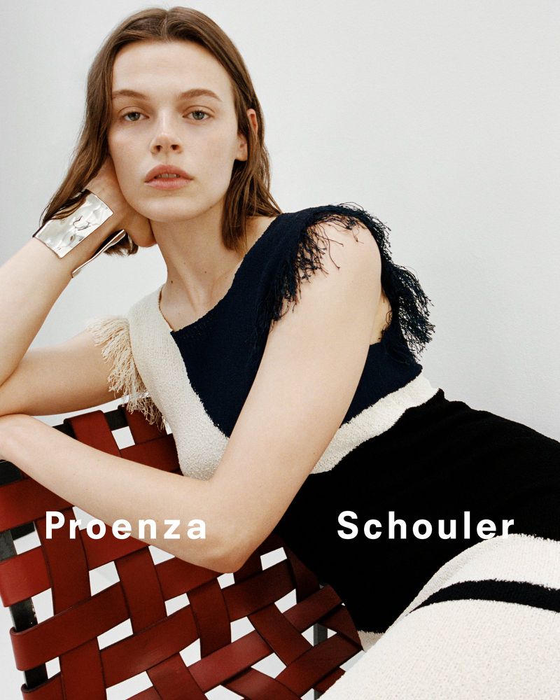 Model Cara Taylor wearing a fringed dress seated on a woven red leather chair for Proenza Schouler