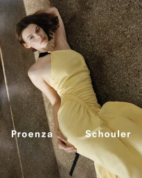 Model wearing a yellow dress lying on a textured ground surface for the Proenza Schouler campaign