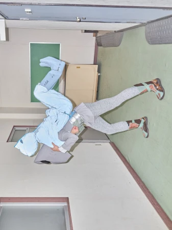 Two figures in abstract outfits pose against an indoor backdrop of walls, window, and door, creating a visually striking editorial image.