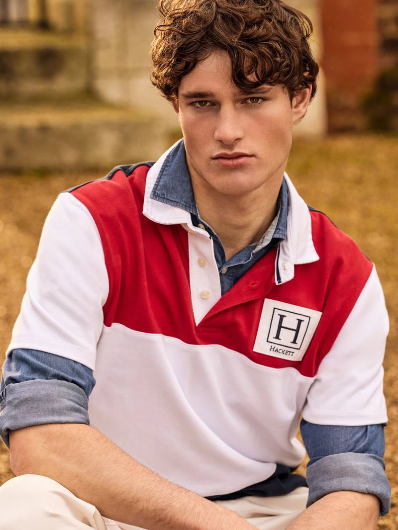 Close-up portrait of a male model wearing a color-blocked rugby shirt and denim shirt outdoors.