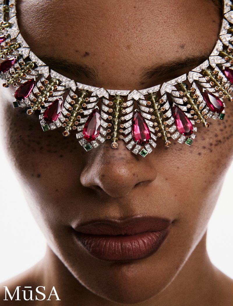 Close-up portrait of a model wearing an ornate diamond necklace across her face like a mask, for La Gema project.