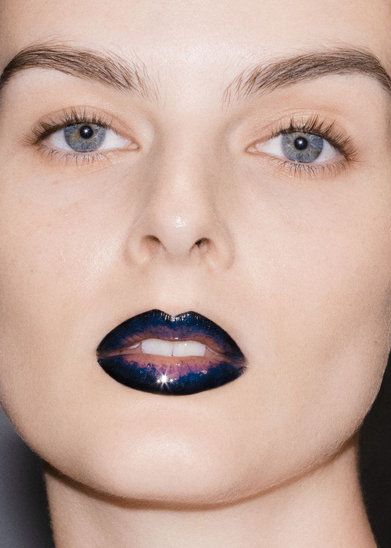 Close-up shot of a female adult with eye makeup and creative, galaxy-themed lip gloss, skincare, and cosmetic concept.