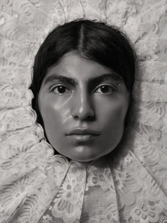 Close-up portrait of a woman framed by intricate white lace ruff collar in monochrome photography