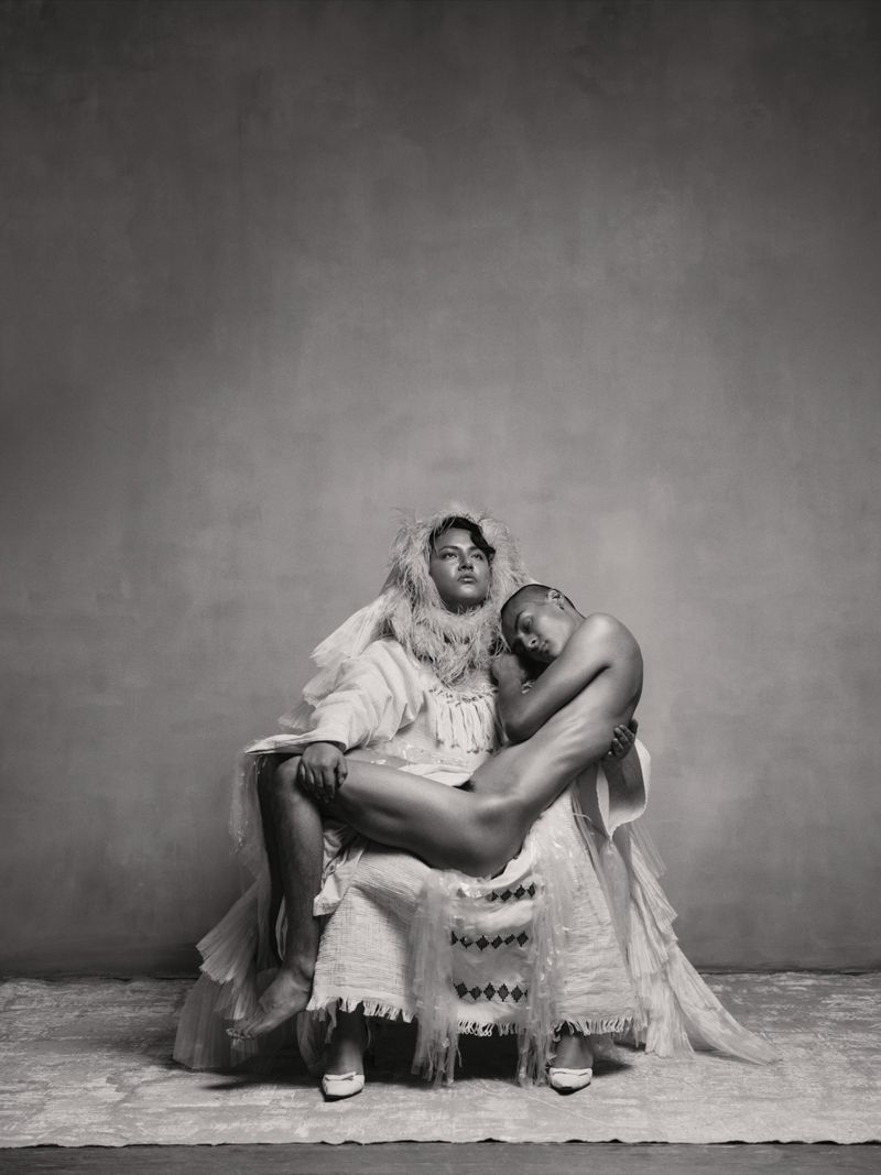 Portrait of two people posed together against a neutral textured studio background, photographed by Pieter Henket.