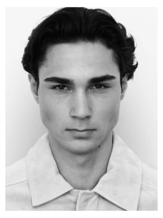 Close-up monochrome portrait of a young man with dark hair against a plain white background for MMScene.