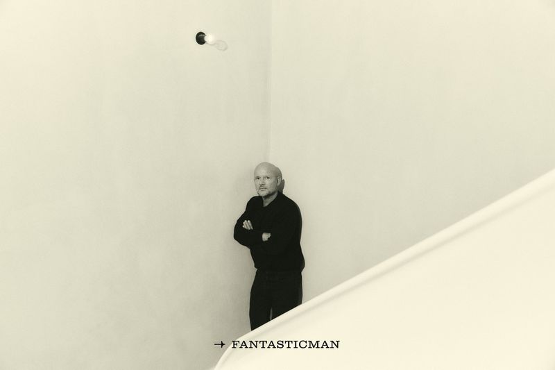Architect Vincent Van Duysen standing with arms crossed in a minimalist corner for Fantastic Man China, photographed by Marcello Junior Dino.