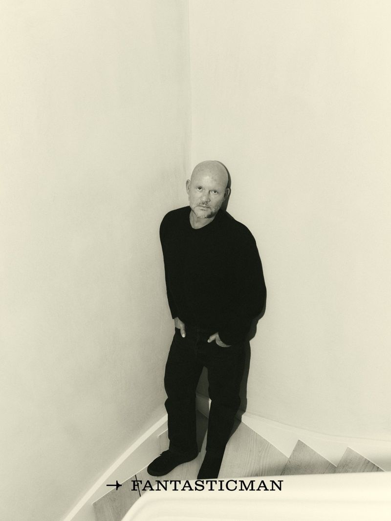 Portrait of Vincent Van Duysen leaning in a corner wearing a black sweater and dark jeans for Fantastic Man China.