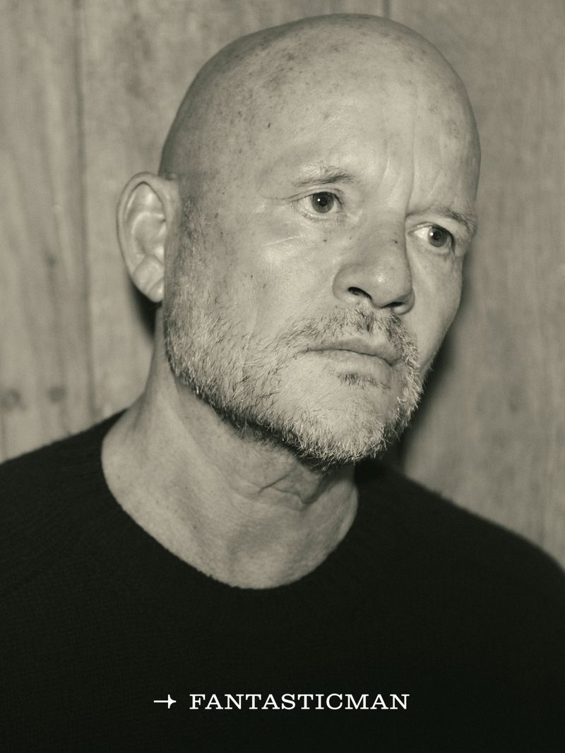Portrait of Vincent Van Duysen wearing a black crewneck top against a wooden paneled wall for Fantastic Man China.