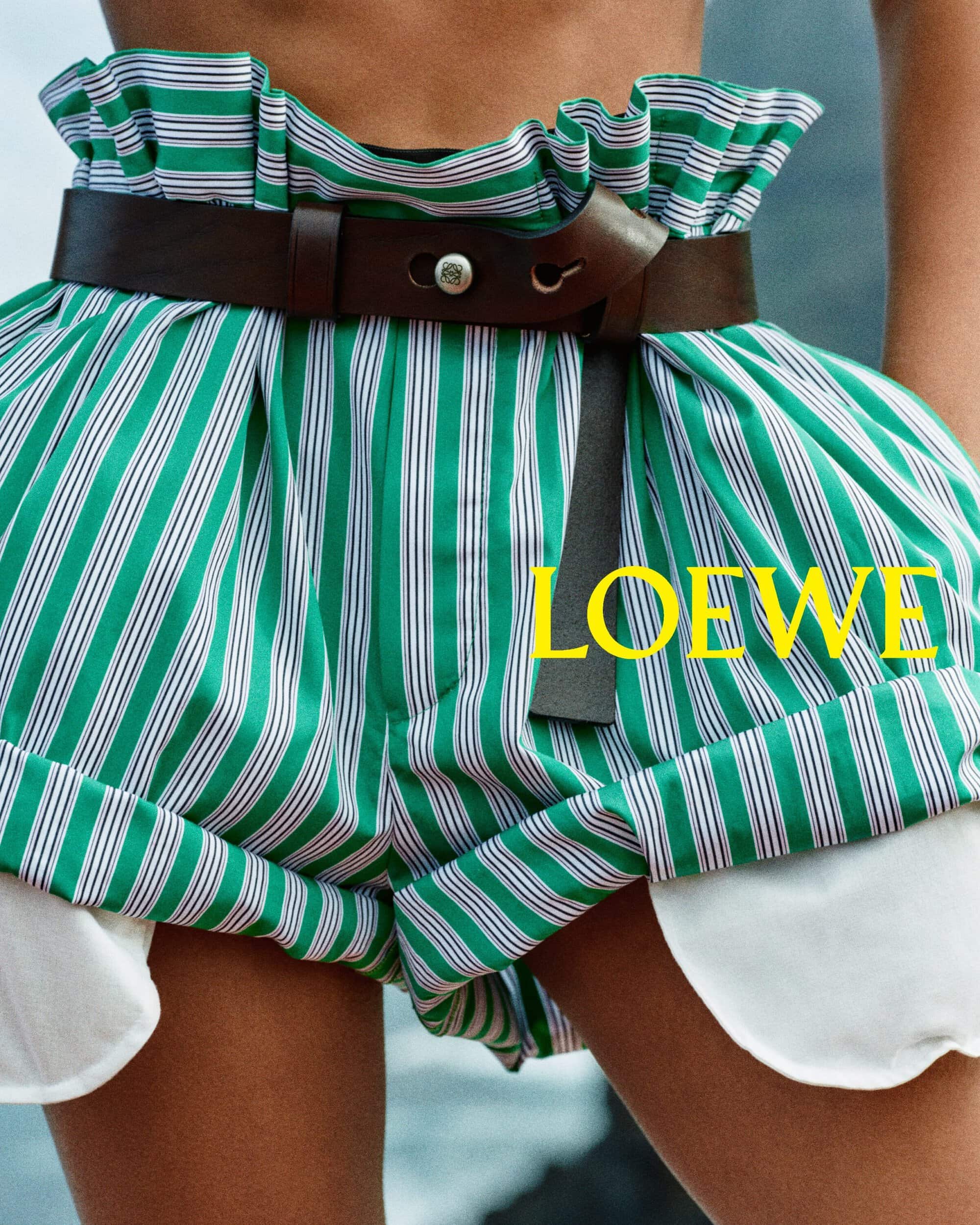 Close-up of green and white striped paperbag waist shorts with a dark brown leather belt for Loewe Pre-Fall 2026