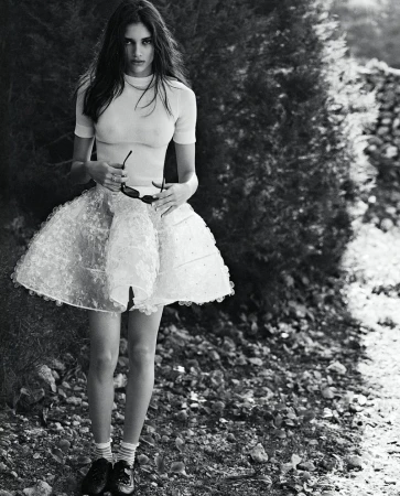 Model Elina Gunawardena posing outdoors wearing a white short-sleeve top and flared skirt for Vogue Netherlands