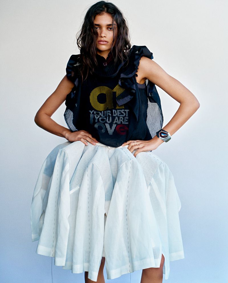 Model wearing a dark sleeveless top and voluminous white skirt against a plain white background for Vogue Netherlands