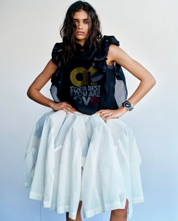 Model wearing a dark sleeveless top and voluminous white skirt against a plain white background for Vogue Netherlands