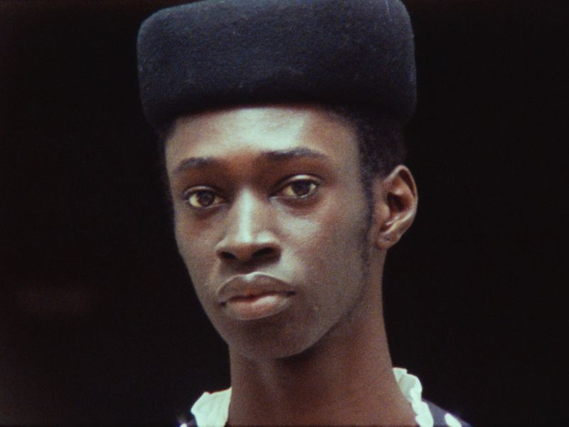 Portrait of a black male model wearing a dark structured hat against a dark background for Luncheon Magazine SS26.