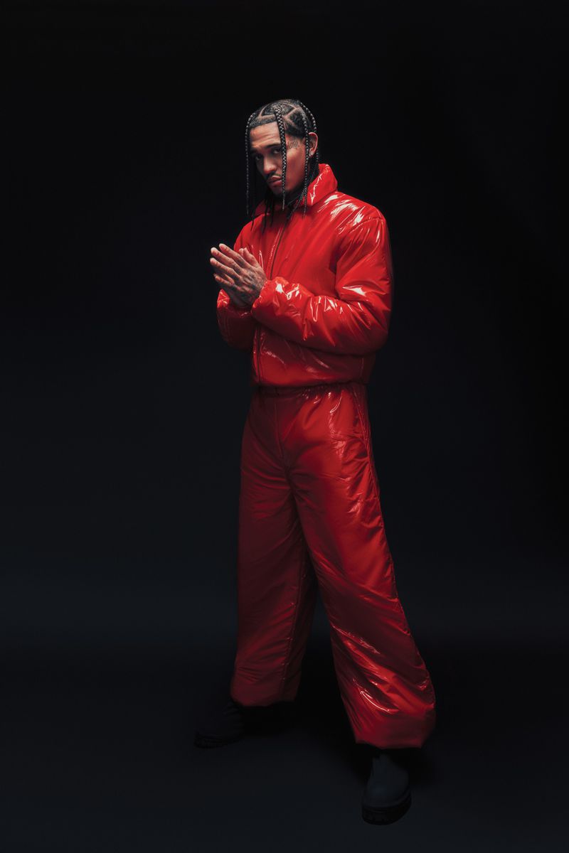 Jordan Clarkson wearing a glossy red puffer jacket and matching trousers against a dark background