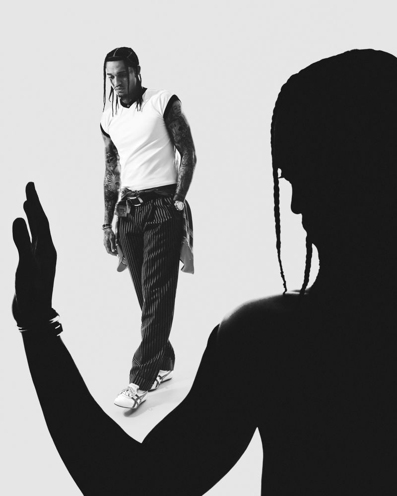 Monochrome portrait of Jordan Clarkson wearing a white t-shirt and striped trousers with a silhouetted figure in the foreground.