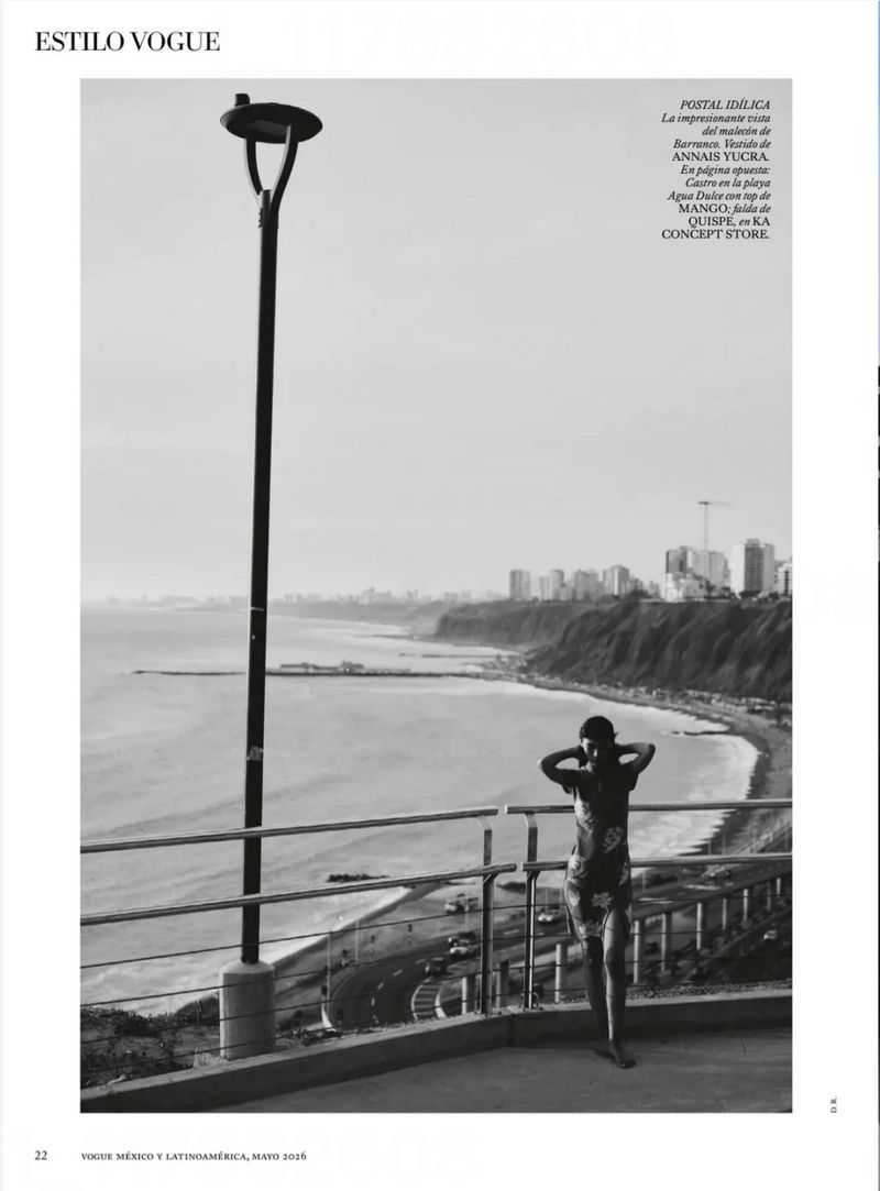Black and white outdoor shot of a woman standing on a patio overlooking the ocean and coastline on a misty day in an editorial style.