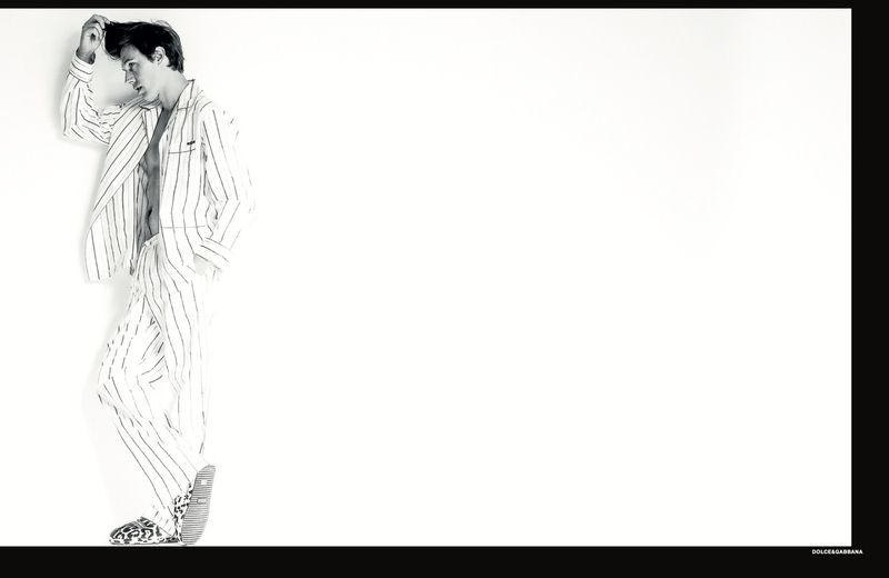 Model in striped pajama-style suit posing against white seamless background for Numéro Homem Brasil