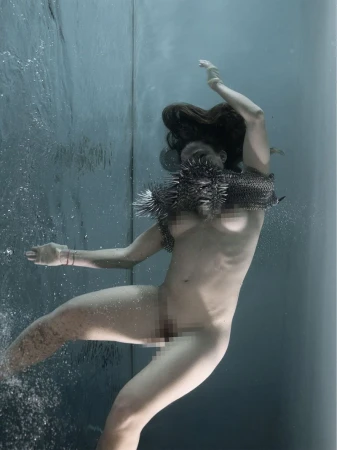 Underwater portrait of a woman wearing chainmail and holding a spiky object for Re-Edition Magazine