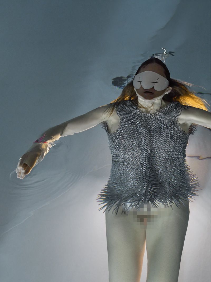 Underwater portrait of Florentina Holzinger wearing a metallic chainmail top and eye mask in Re-Edition Magazine