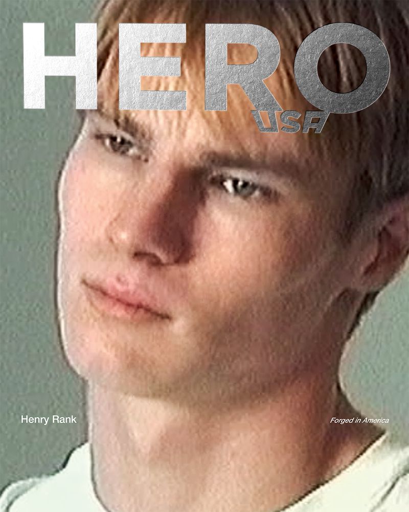 Close-up portrait of model Henry Rank wearing a white t-shirt against a muted grey background for HERO USA