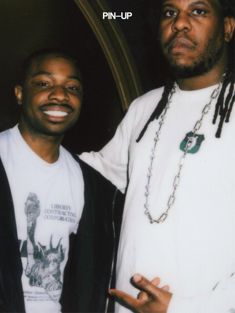 Two black men standing together indoors with PIN-UP branding visible at the top.