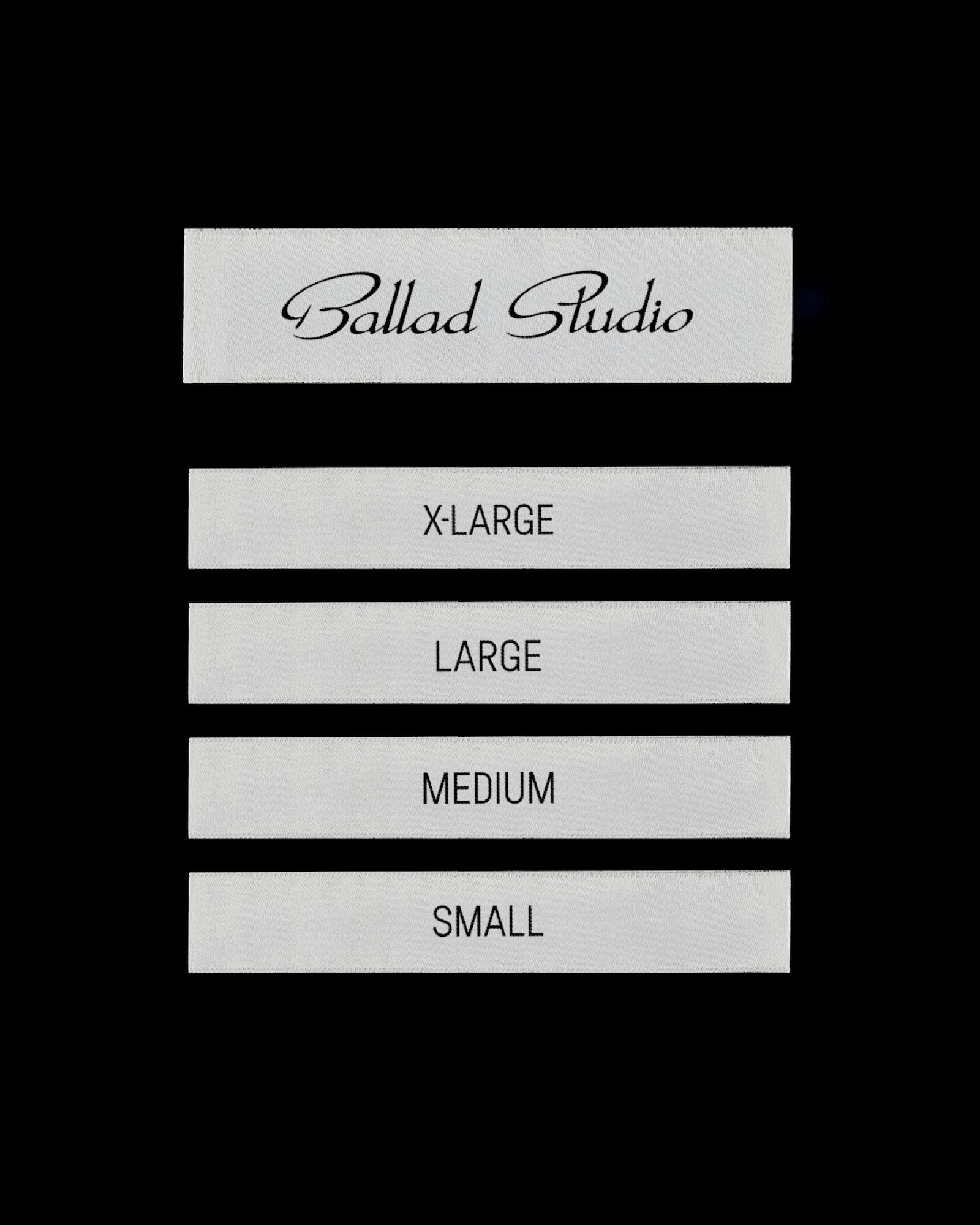 Ballad Studio brand identity clothing size labels showing extra large, large, medium, and small tags on a black background.