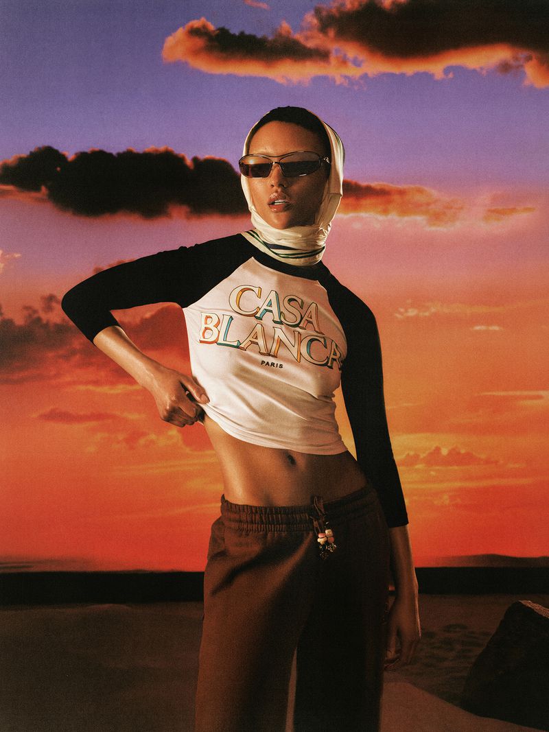 Model wearing Casablanca ringer top and sunglasses with headscarf against sunset sky