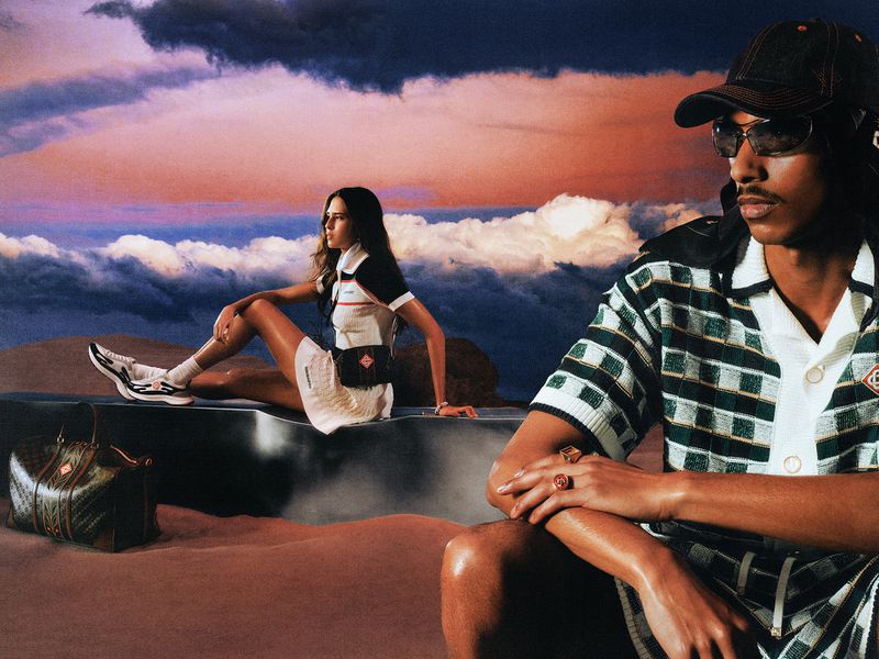 Two models in Casablanca Pre-Fall 26 campaign outdoors with dramatic sunset sky and desert ground