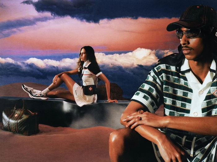 Two models in Casablanca Pre-Fall 26 campaign outdoors with dramatic sunset sky and desert ground