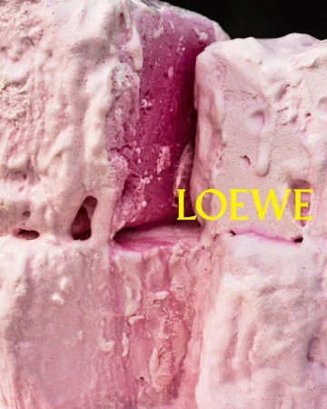 Abstract close-up of pink block-like objects covered in a white, icing-like substance, with the text “LOEWE” overlaid in yellow.