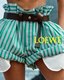 Close-up of green and white striped paperbag waist shorts worn with a dark brown leather belt for Loewe.