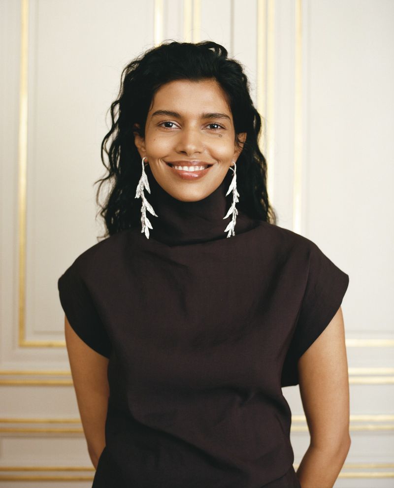 Model Pooja Mor wearing drop leaf earrings and a dark turtleneck in a portrait for Boucheron Special